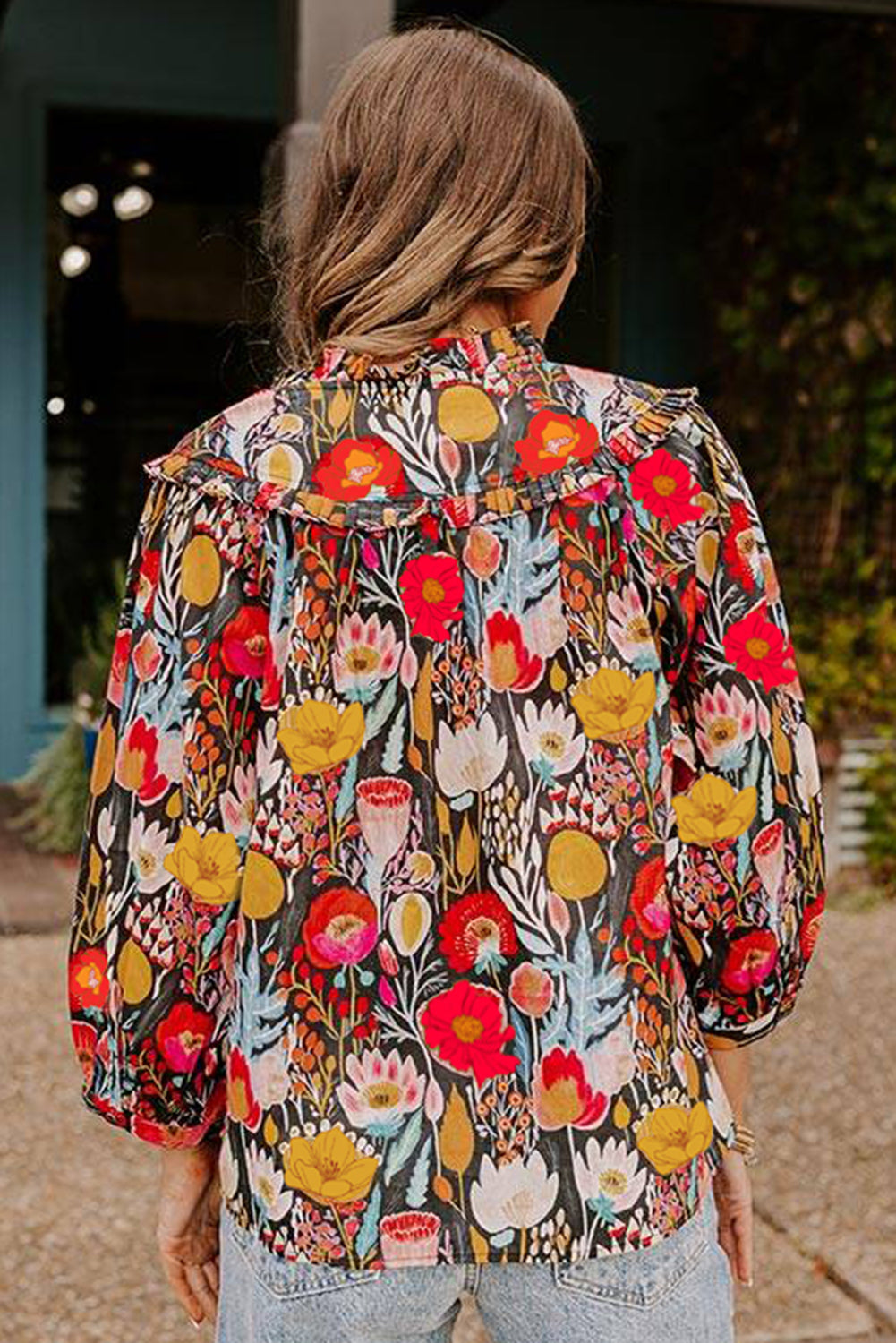 Blusa negra con estampado floral, mangas abullonadas 3/4 y cuello con volantes