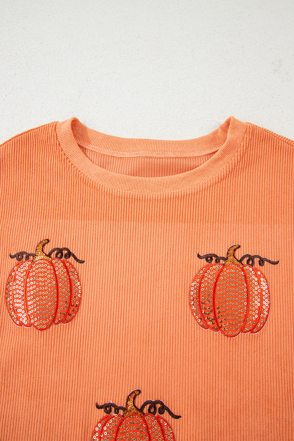 Esta sudadera con cordón con un estampado de calabaza con lentejuelas.