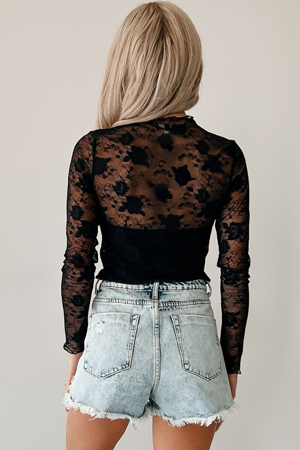 Top negro de manga larga con encaje floral y cuello alto