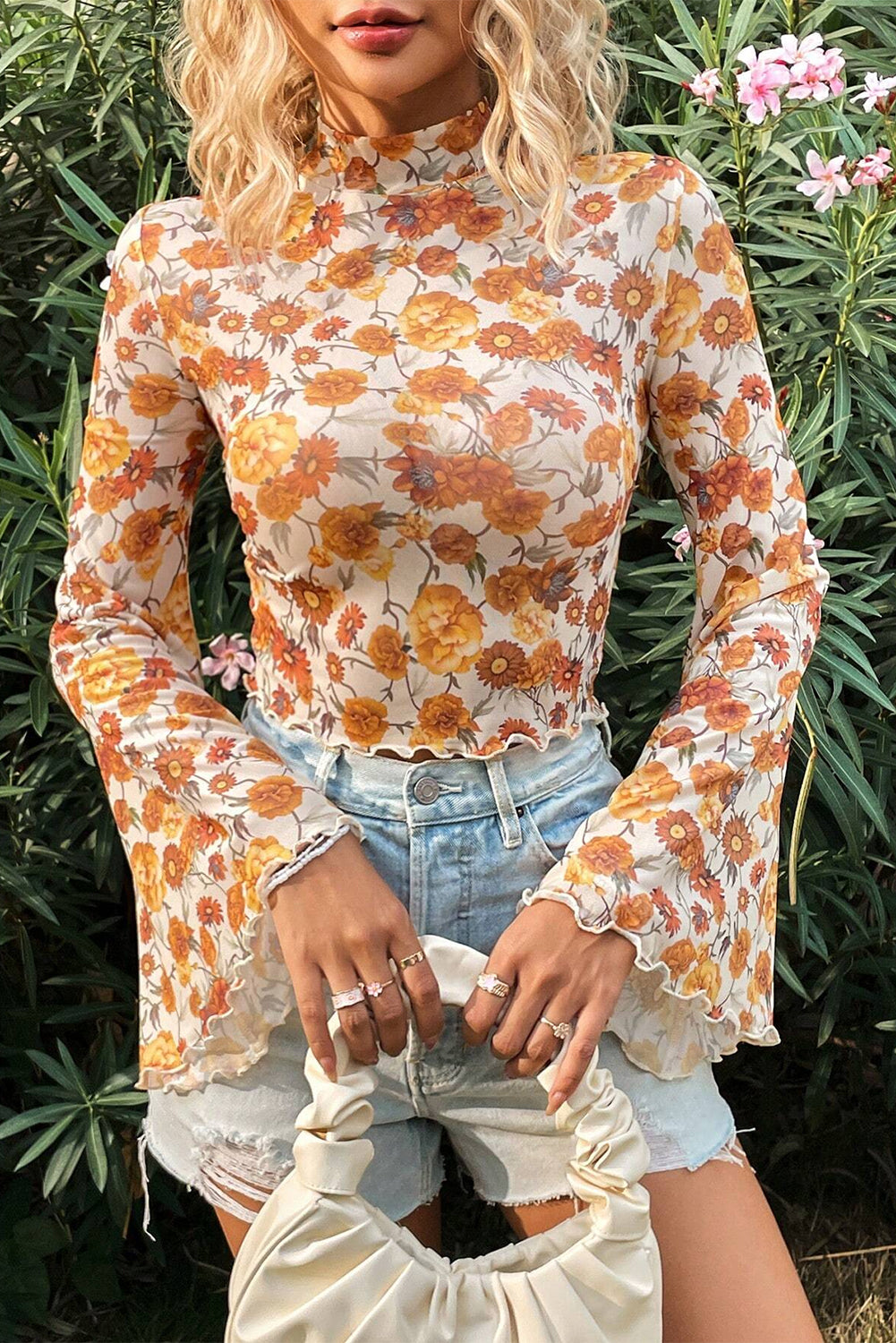 Blusa con estampado floral naranja, mangas acampanadas, cuello alto y ribete festoneado