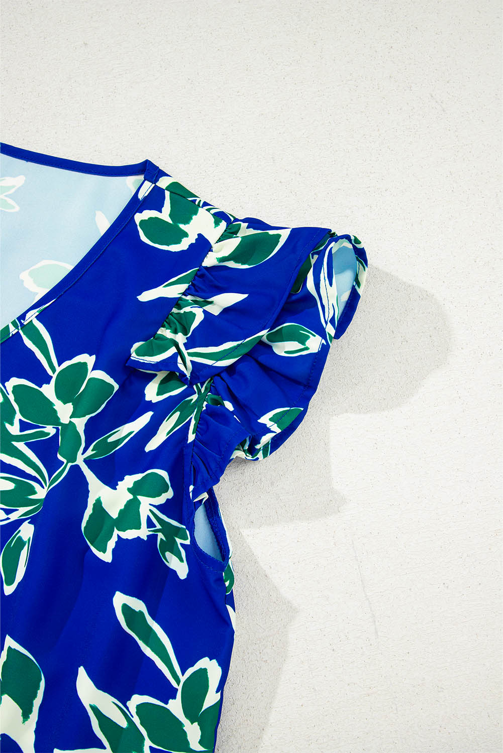 Blusa azul de manga corta con volantes, cuello en V y estampado floral