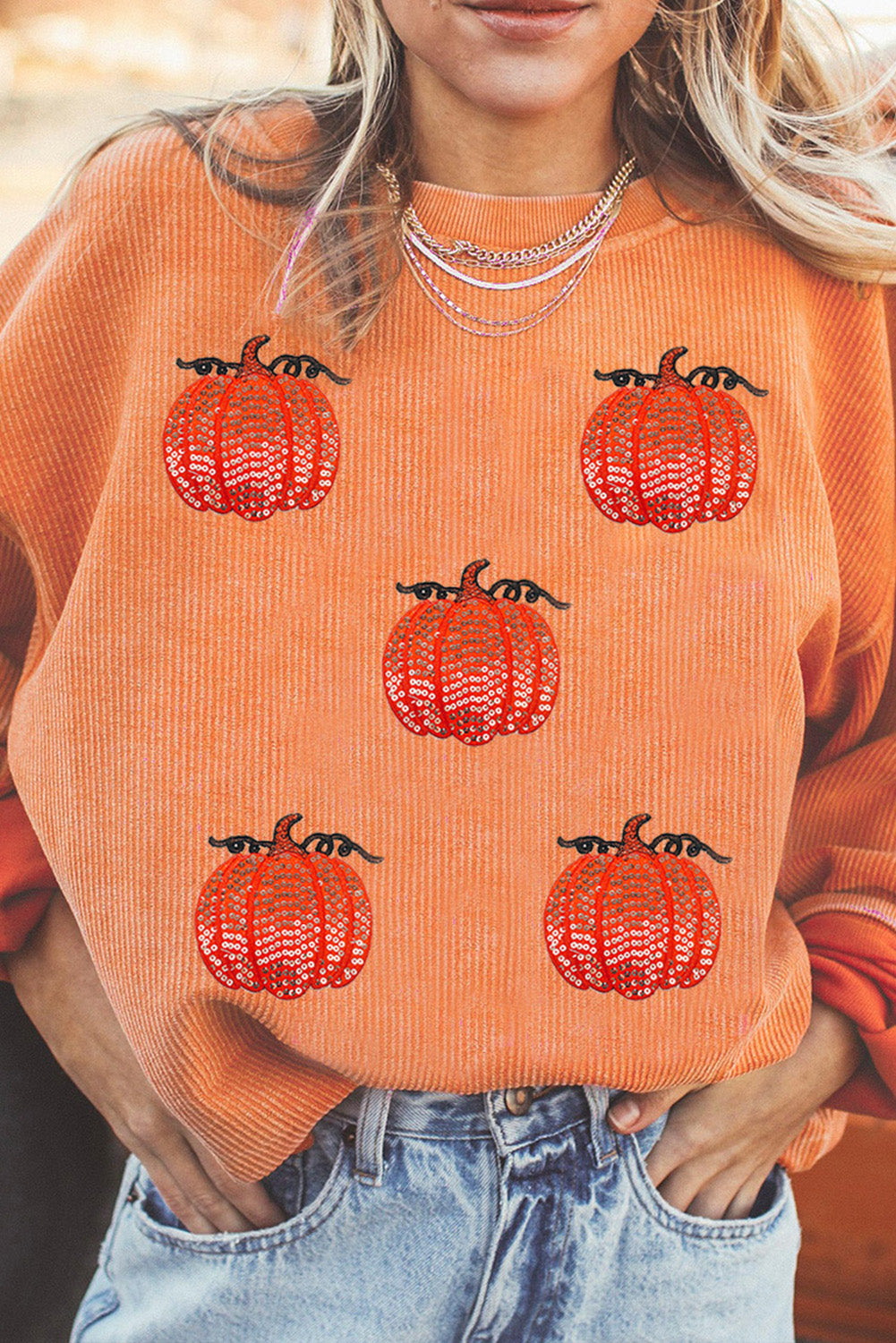 Esta sudadera con cordón con un estampado de calabaza con lentejuelas.
