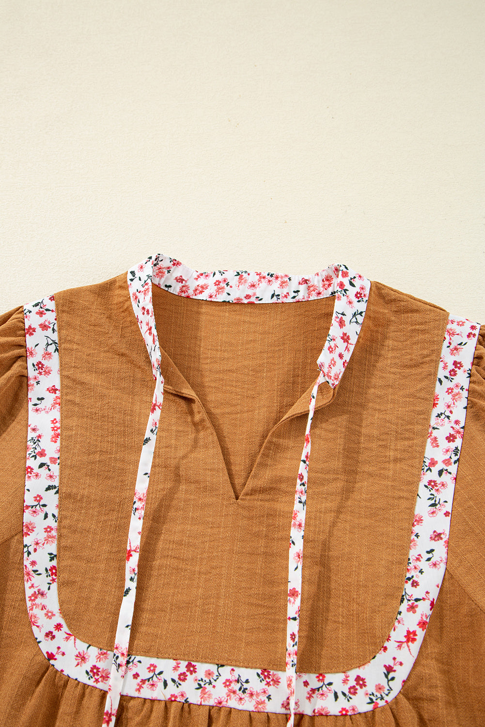 Blusa plisada con cuello abierto, ribete floral y mangas abullonadas de color amarillo paja