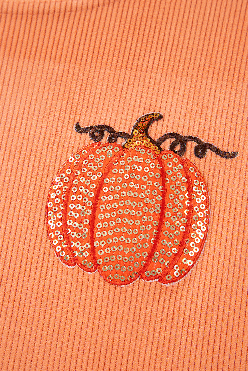 Esta sudadera con cordón con un estampado de calabaza con lentejuelas.