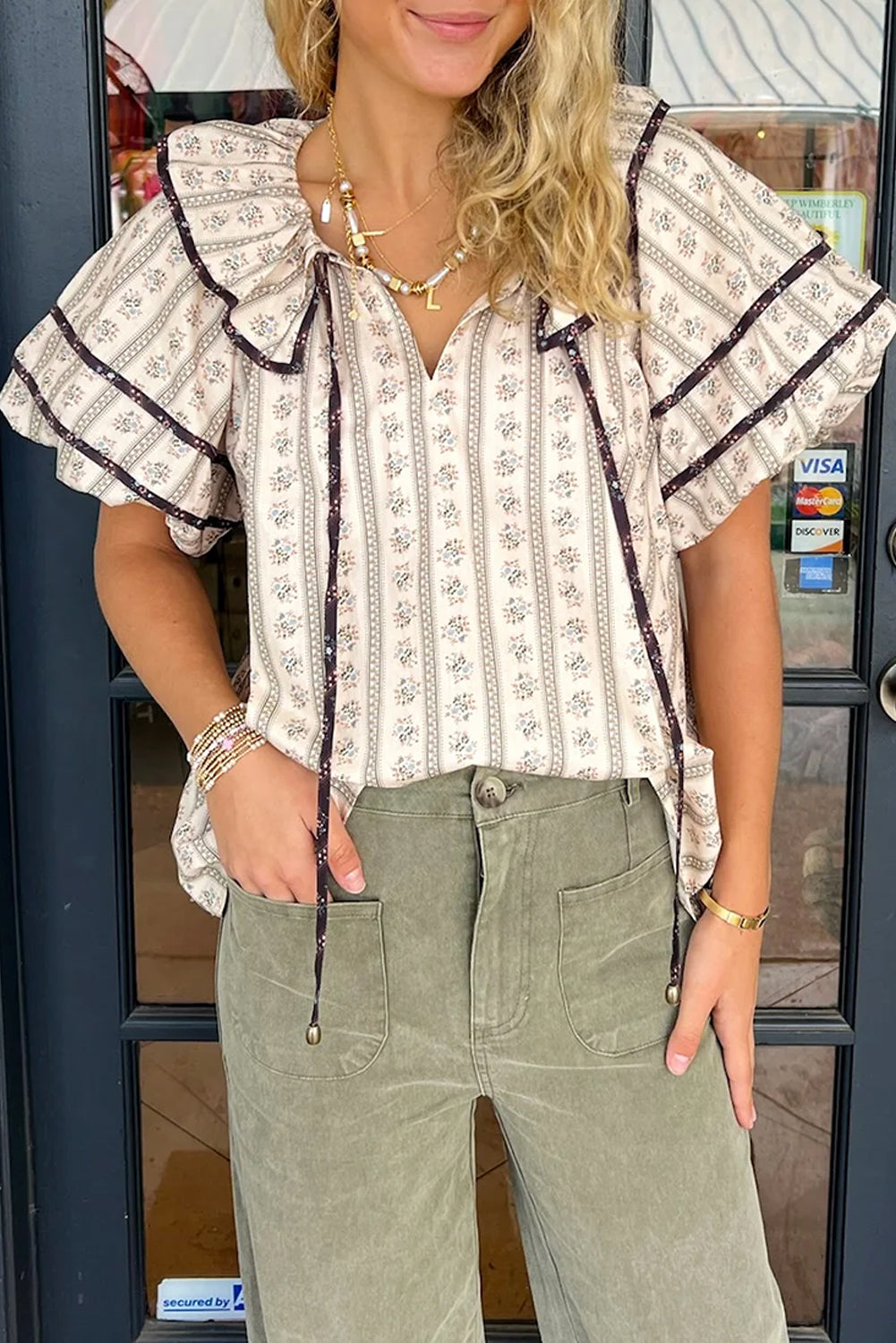 Blusa blanca con estampado floral, cuello con volantes y mangas abullonadas cortas
