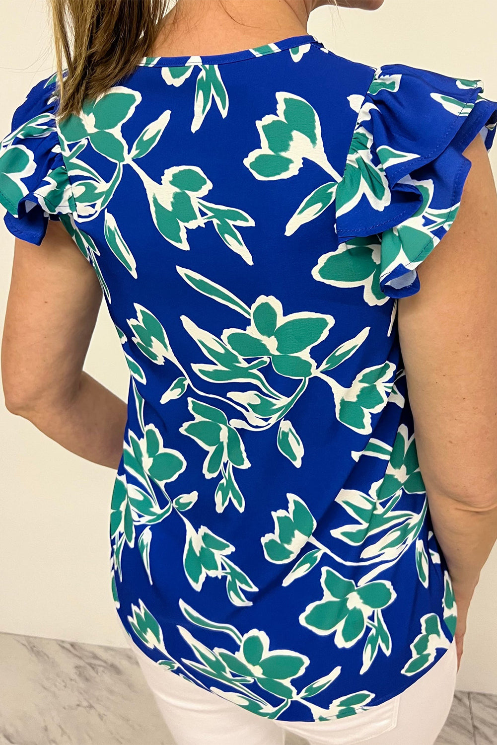 Blusa azul de manga corta con volantes, cuello en V y estampado floral