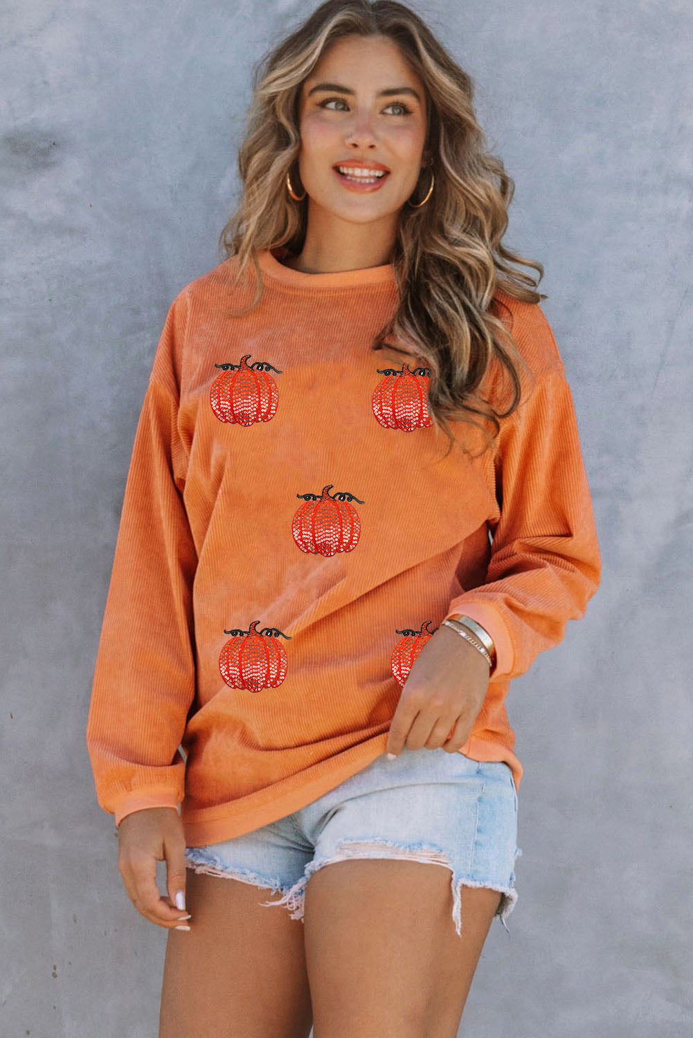 Esta sudadera con cordón con un estampado de calabaza con lentejuelas.