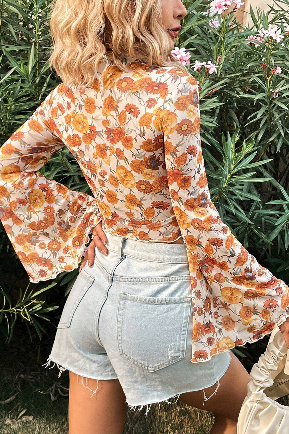 Blusa con estampado floral naranja, mangas acampanadas, cuello alto y ribete festoneado