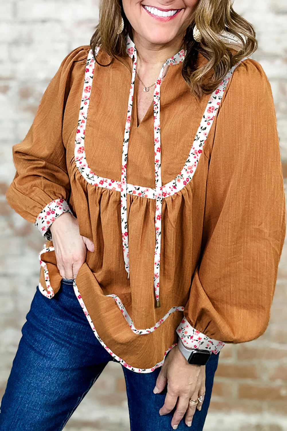 Blusa plisada con cuello abierto, ribete floral y mangas abullonadas de color amarillo paja