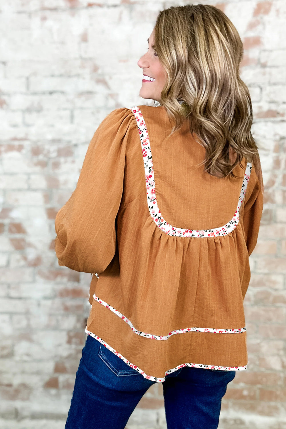 Blusa plisada con cuello abierto, ribete floral y mangas abullonadas de color amarillo paja