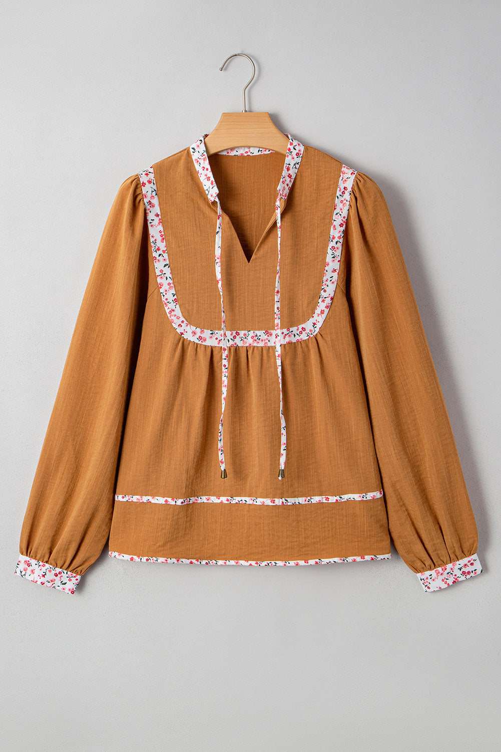 Blusa plisada con cuello abierto, ribete floral y mangas abullonadas de color amarillo paja